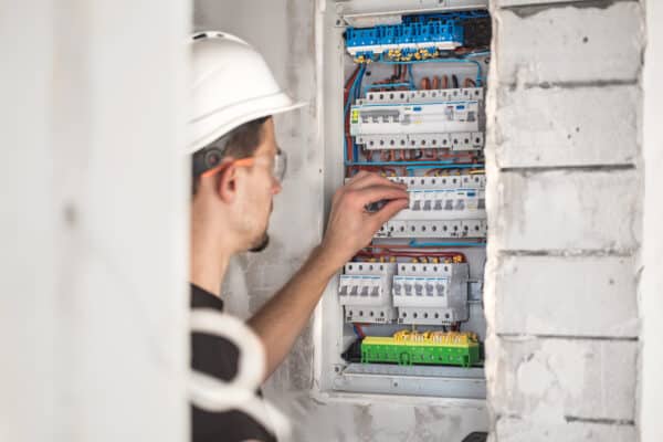 Man, An Electrical Technician Working In A Switchboard With Fuses. Installation And Connection Of Electrical Equipment.